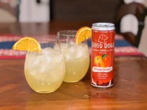 Orange Mango Screwdriver cocktail next to a can of Good Dogg.